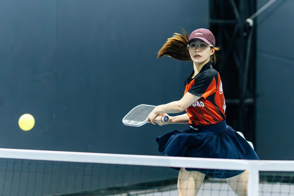 Pickleball player mid-swing